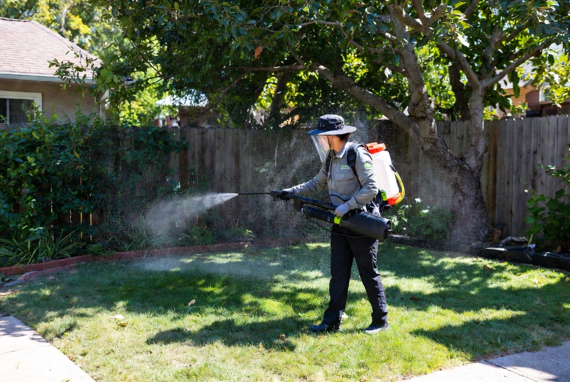 Lawn Spark technician applying professional mosquito control treatment to a shaded backyard in Oklahoma City.
